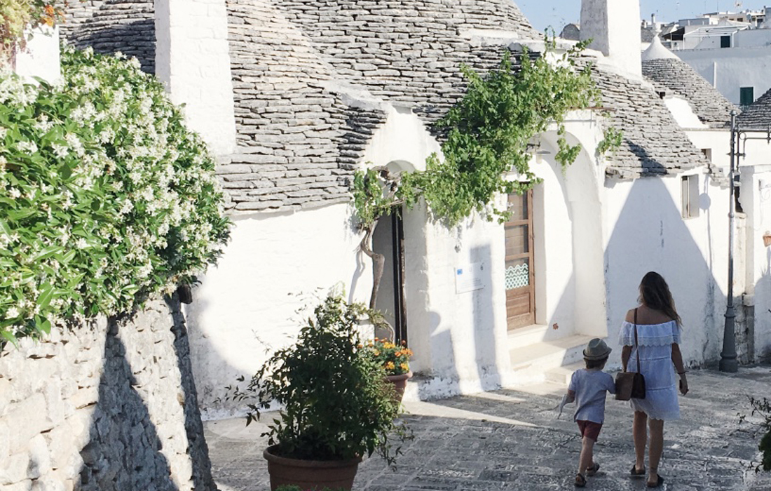 I trulli di Alberobello, Rione Monti, una donna e un bambino per mano di schiena