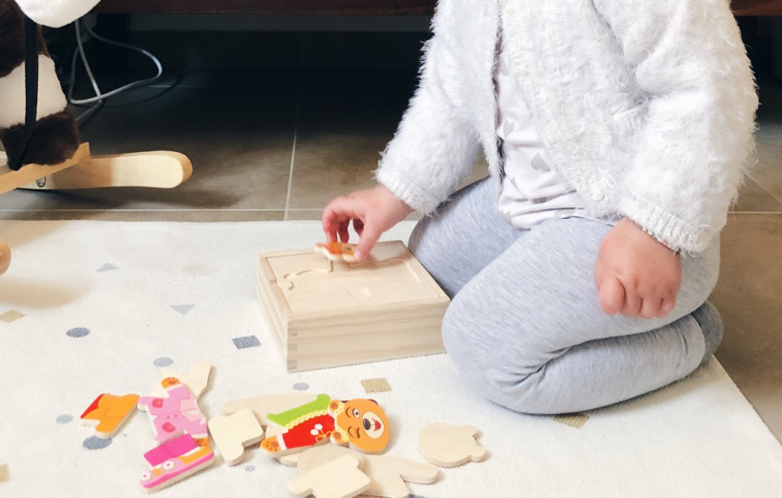 bambina i ginocchio riordina gioco in legno a incastro